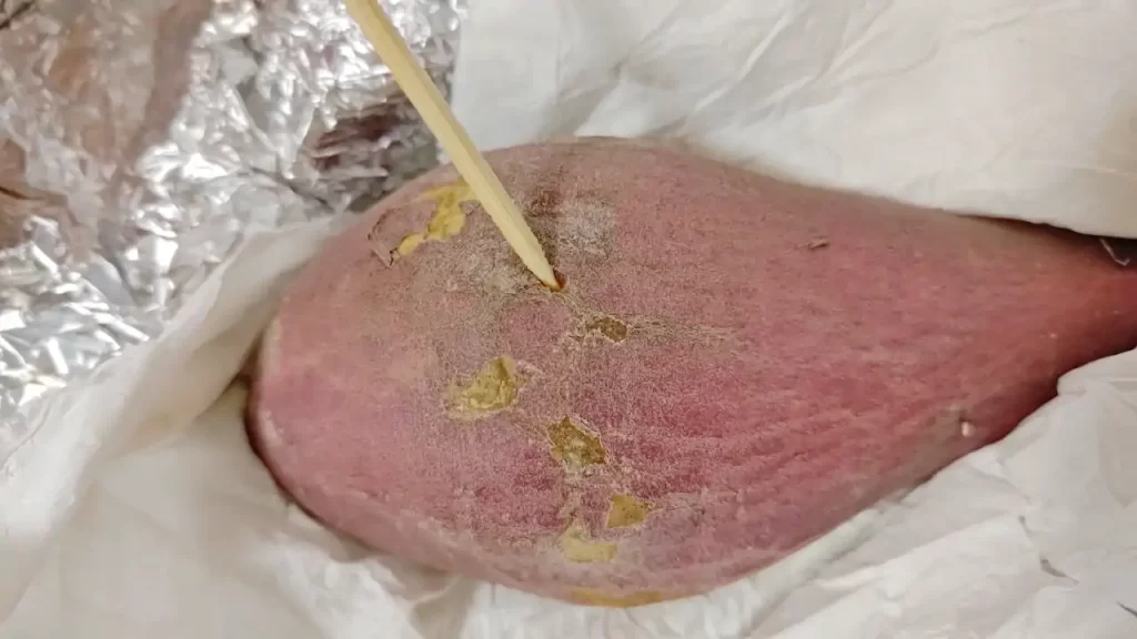 焼き上がった『なると金時』の焼け具合をチェックしているところ