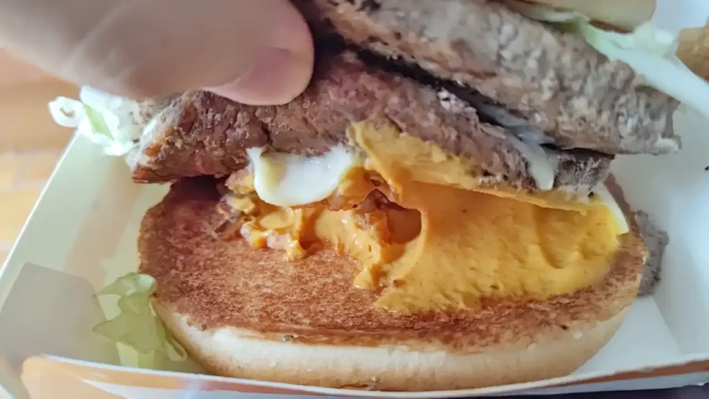 台湾マクドナルドの新商品『ビッグアーチ（霸牛堡）』のチーズソースと溶けた白いチーズ、揚げタマネギ